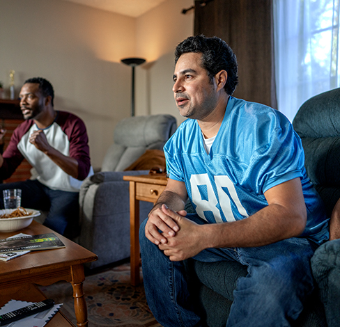 Two men watching a football game on TV