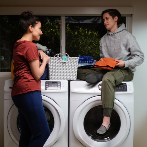 Two women chatting in a laundry room