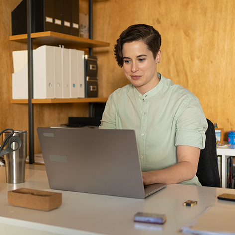 Woman typing on a laptop in her office