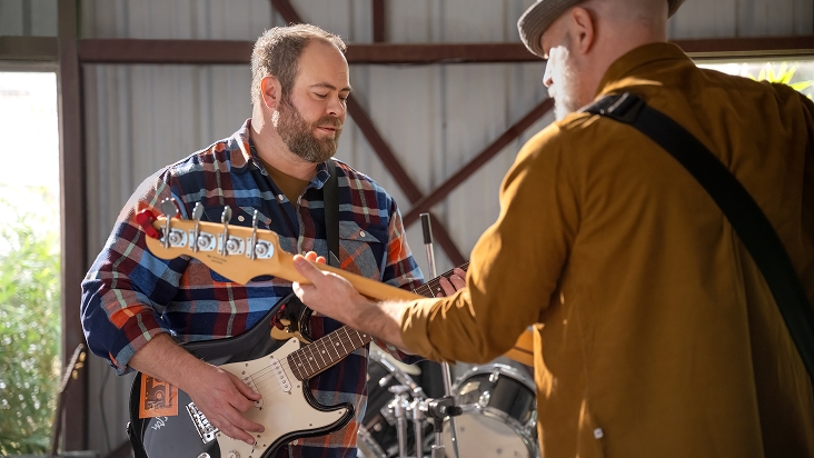 Two men playing a guitar