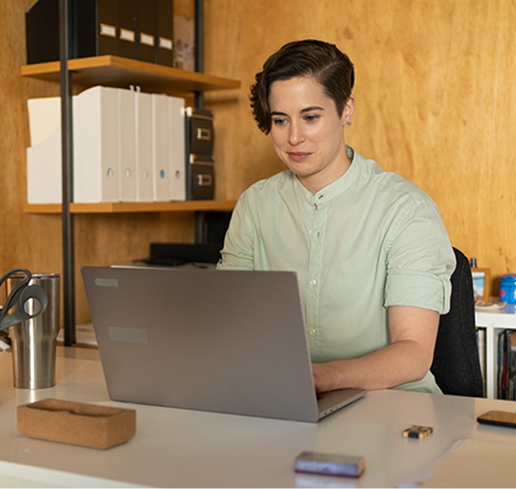 Woman typing on a laptop in her office